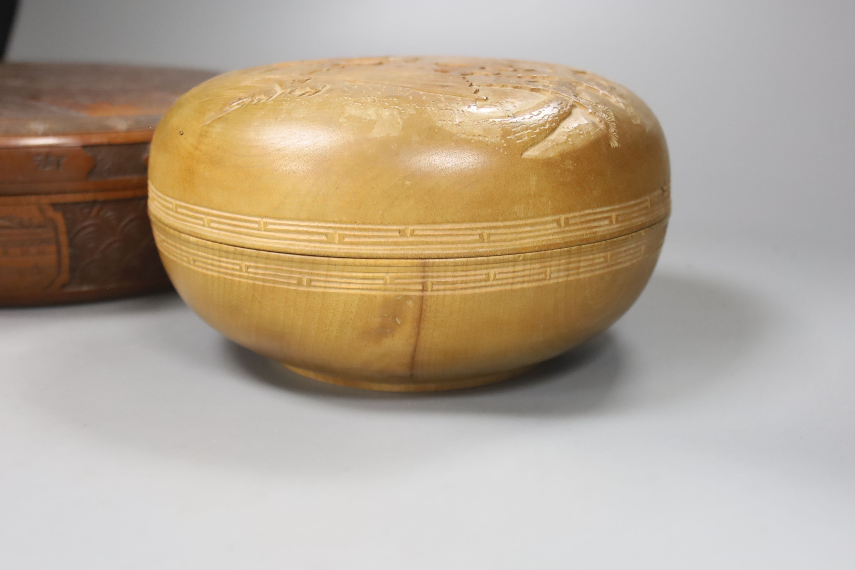 Two Japanese shallow carved wood circular lidded boxes, largest 27cm diameter